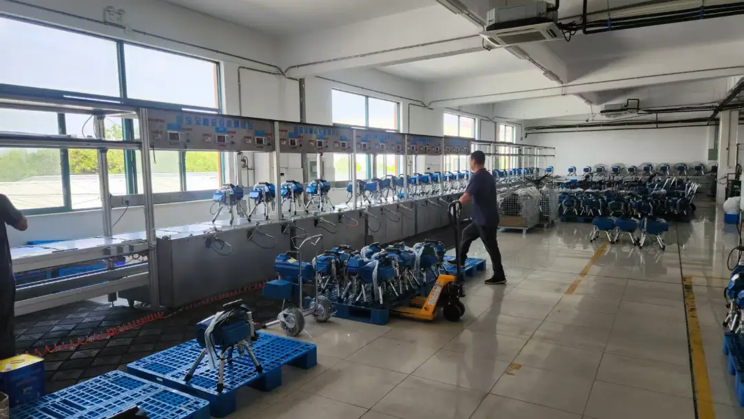 Large-scale GUTUBAO OEM factory production line featuring rows of professional industrial stucco sprayer machines, demonstrating high-volume manufacturing capacity and quality control.